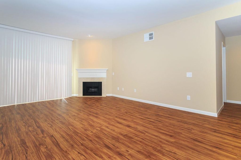 Apartments in Toluca Lake An empty living room in Toluca Lake with hardwood floors and a fireplace.